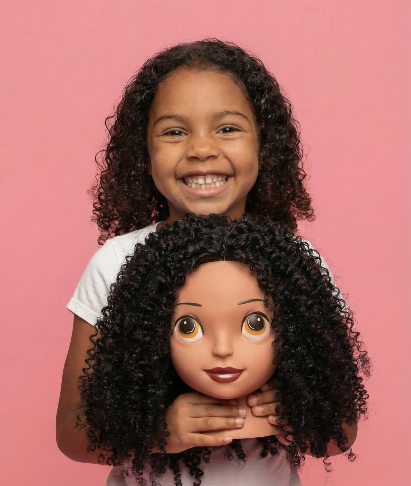 Child holding a doll with curly hair against a pink background